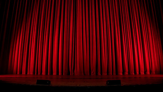Closed red stage curtain evoking classic Hollywood glamour, hinting at the hidden spotlight on left-handed legends behind the scenes.