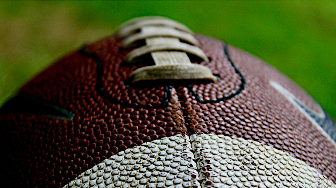 Close-up of an American football resting on a black background, symbolizing the legacy of left-handed quarterbacks and their unique place in NFL history.