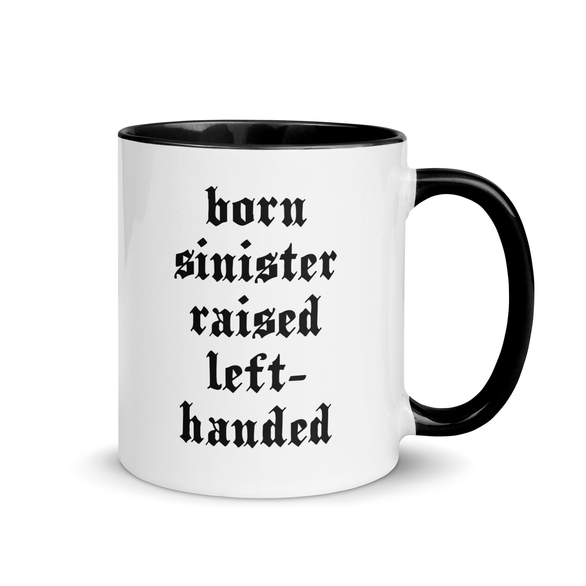 White ceramic mug for left-handers featuring black gothic text "Born Sinister Raised Left-Handed" with black handle and interior.