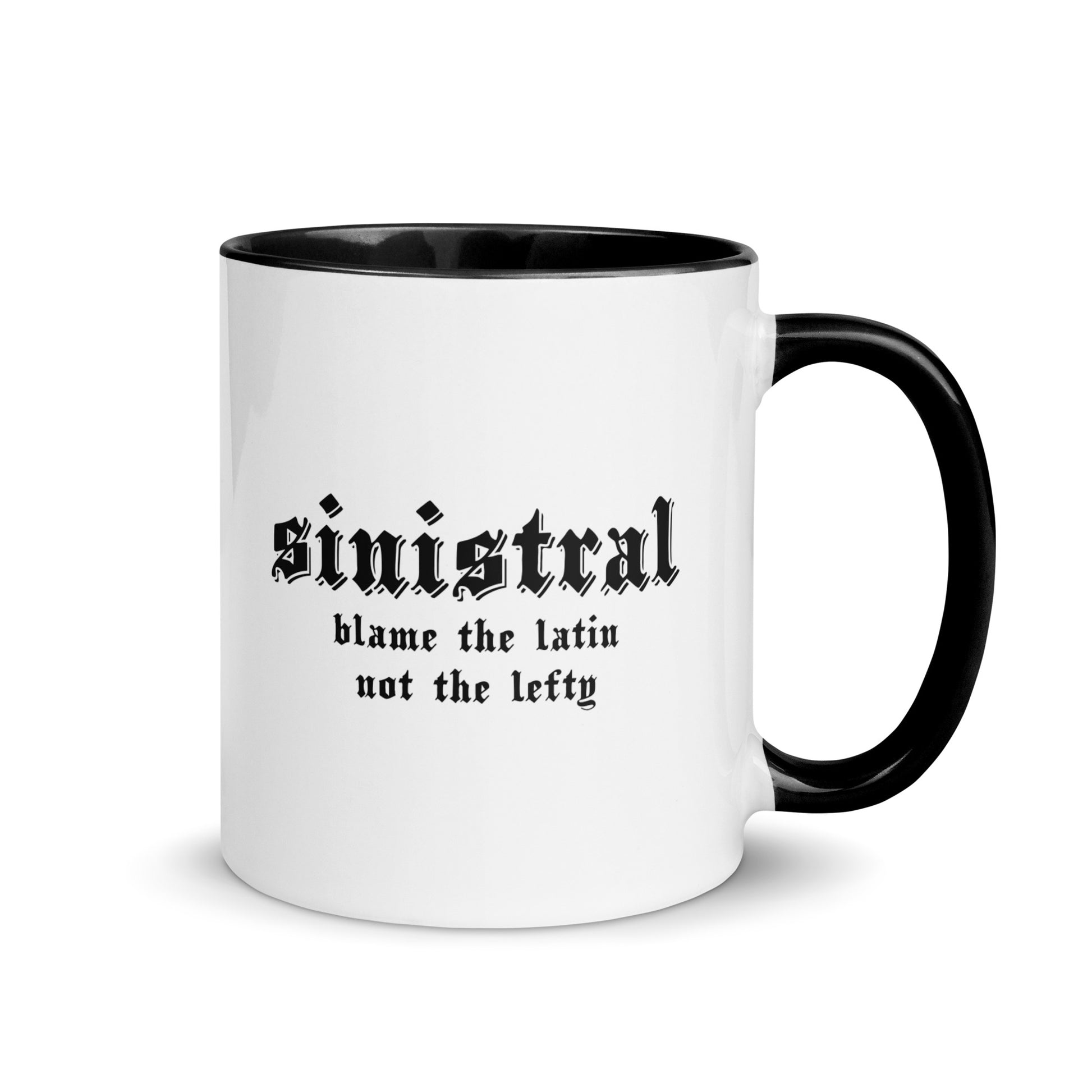 White ceramic mug for left-handers featuring black gothic text "Sinistral: Blame the Latin Not the Lefty" with black handle and interior.