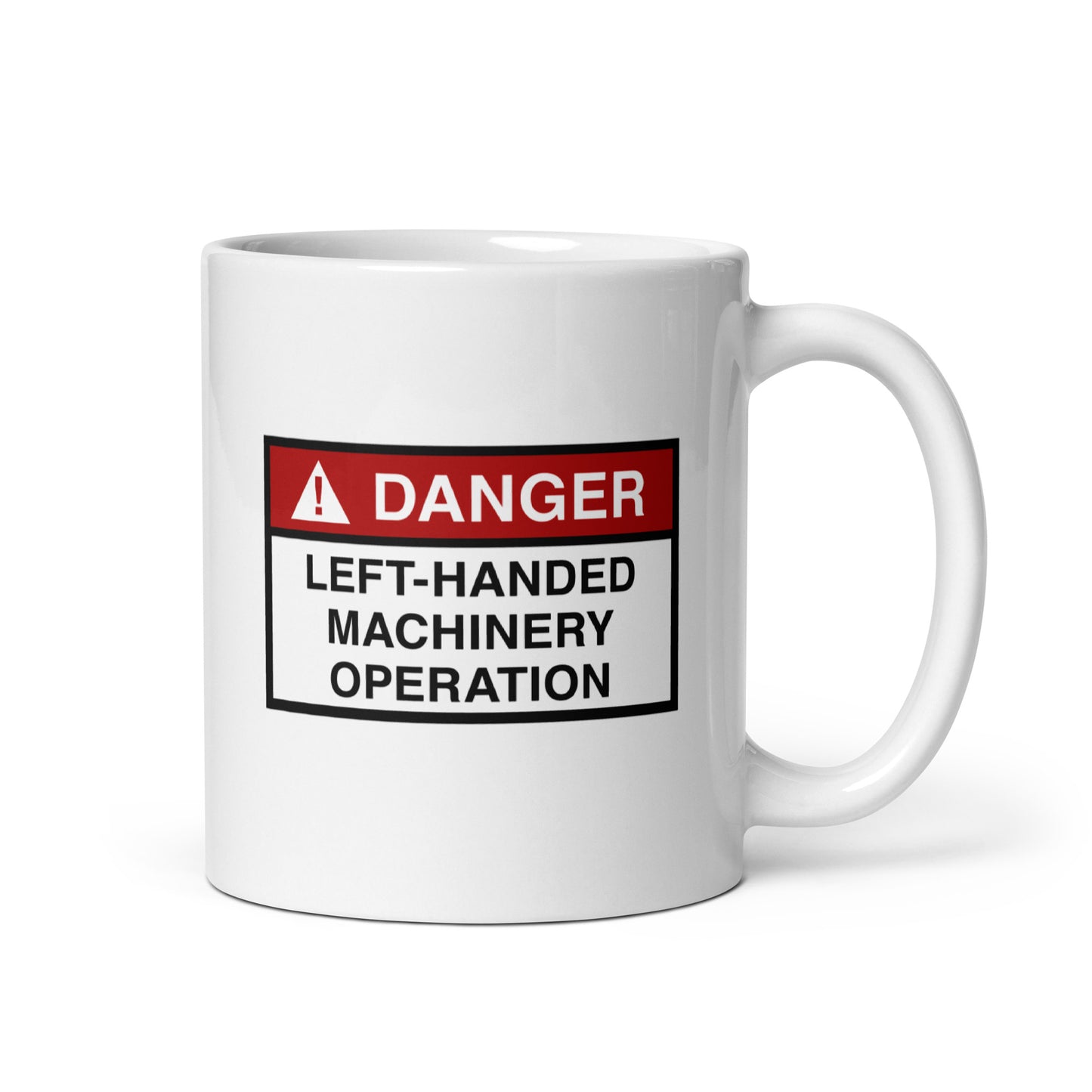 White ceramic mug for left-handers with a danger left-handed machinery operation hazard sign design