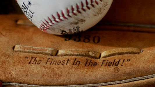 Close-up of a leather baseball glove holding a baseball.