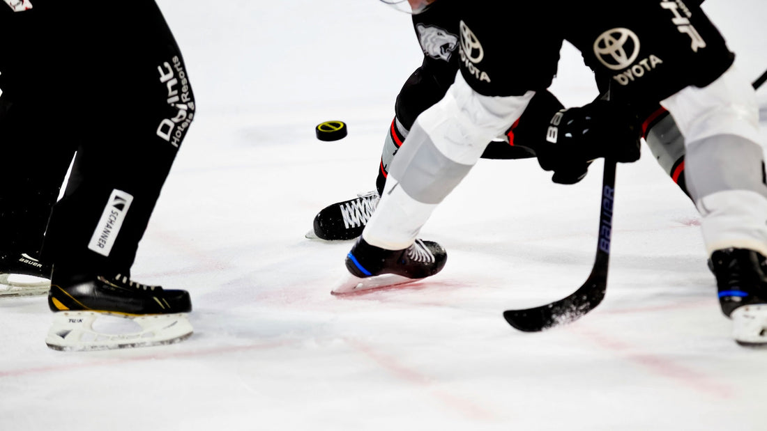 A close-up action shot of hockey players mid-stride, handling the puck, showcasing precision and skill left-handed shooters are known for on the ice.