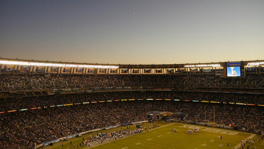 An NFL game unfolds at sunset, with players in motion under the golden sky. A tribute to the rare left-handed players who have left their mark on the game.