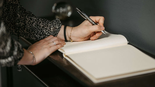 Close-up of a left-handed woman writing in a guestbook.