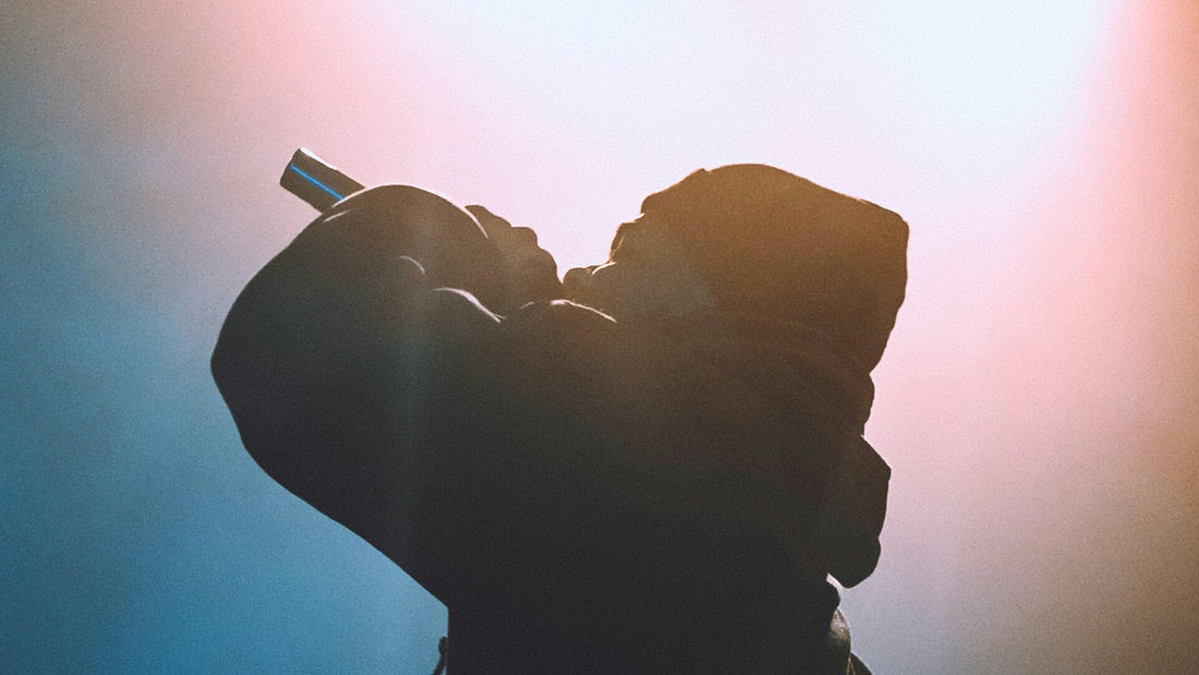 Silhouette of a man holding a microphone in his left hand, symbolizing left-handed creativity and expression in music.