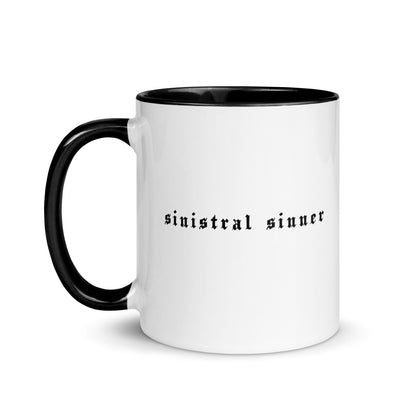 White ceramic mug for left-handers featuring black gothic text "Sinistral Sinner" with black handle and interior.