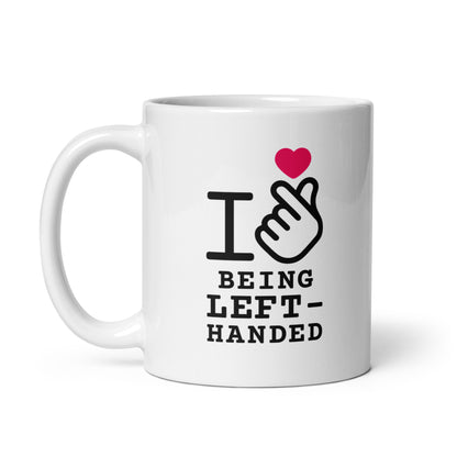 White mug with 'I ❤️ BEING LEFT-HANDED' text and heart design on a white background