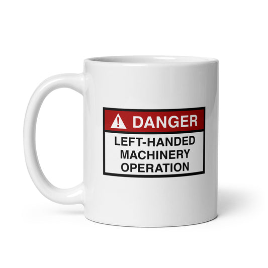 White ceramic mug for left-handers with a danger left-handed machinery operation hazard sign design